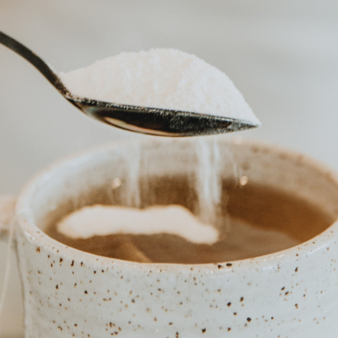 A heaped teaspoon of Adashiko Pure Collagen powder being added to a cup of coffee | Adashiko Collagen | 100% Natural Skincare