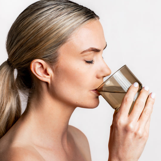 Model drinking a glass of water with Pure Collagen Powder dissolved | Adashiko Collagen 100% Natural Skincare