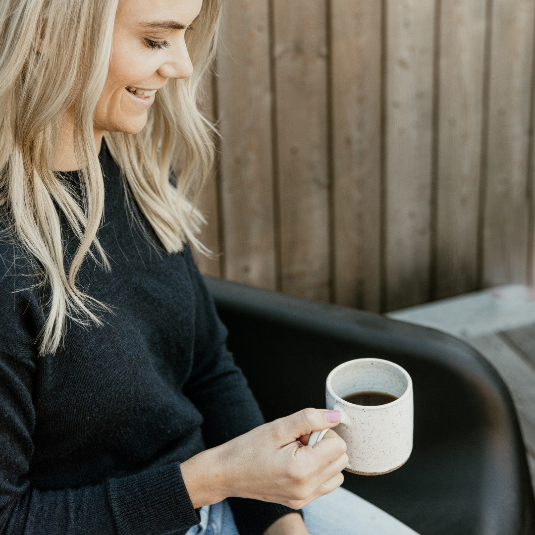 Woman sitting outside holding a mug of coffee | Adashiko Collagen | 100% Natural Skincare