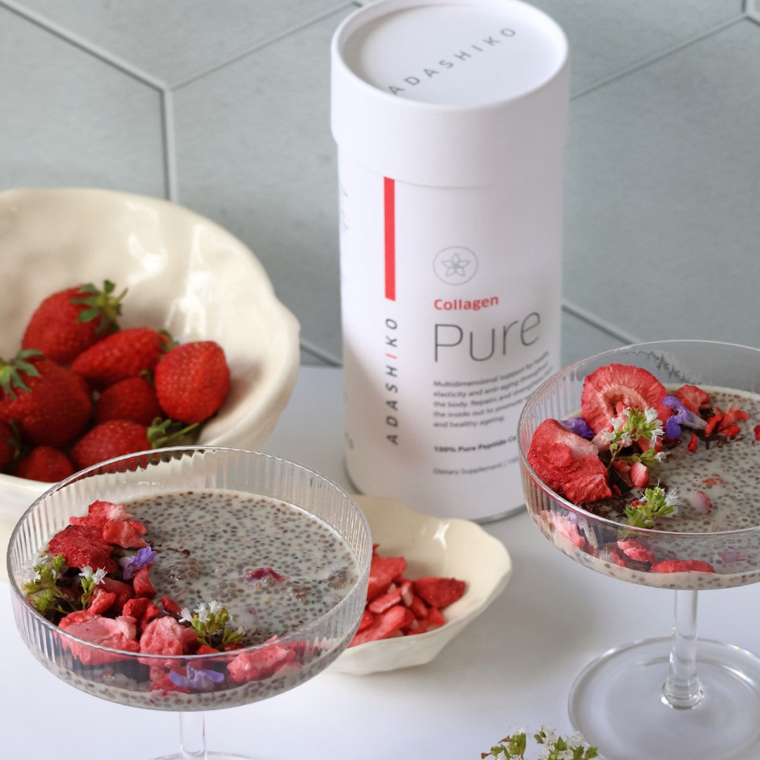 Two glass bowls of Strawberry + Chia Seed Collagen Pudding next to a bowl of strawberries and a tub of Pure Collagen powder | Adashiko Collagen | 100% Natural Skincare