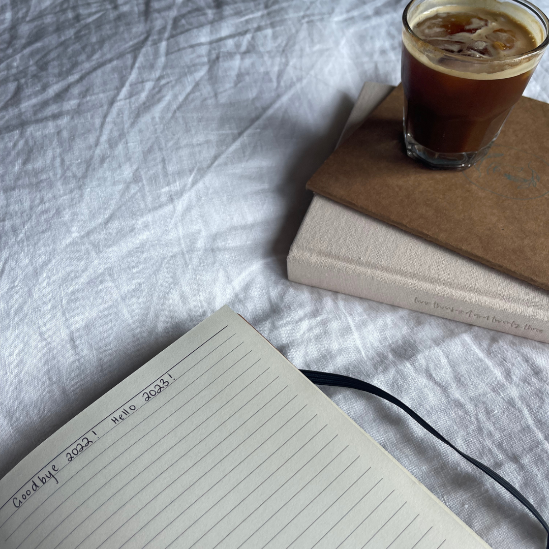 Mindful Journaling - Notebook open next to drink cup | Adashiko Collagen | 100% Natural Skincare