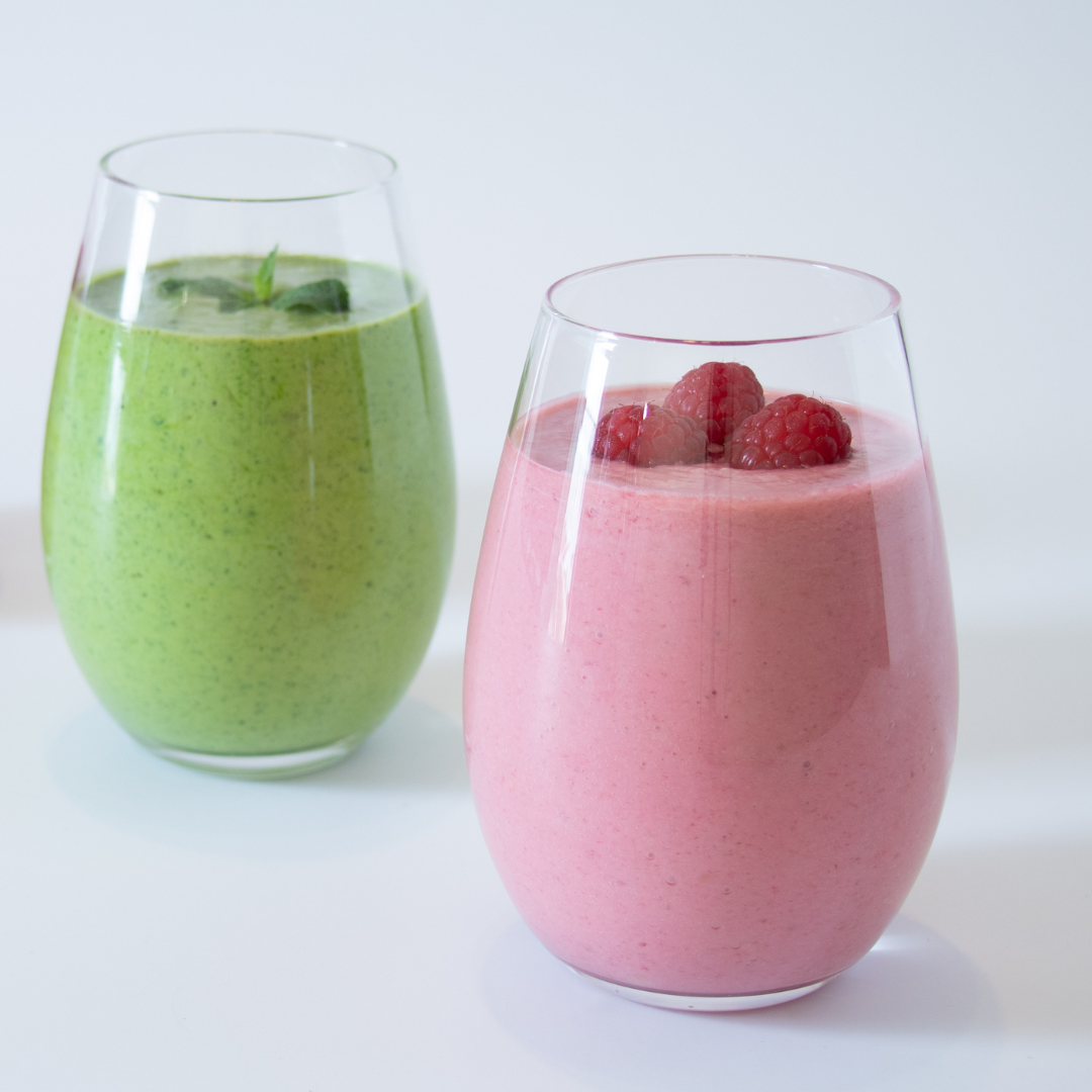 Antioxidant Blast Berry Banana Smoothie in front of a Antioxidant Supercharged Green Smoothie both in a clear glass | Adashiko Collagen | 100% Natural Skincare