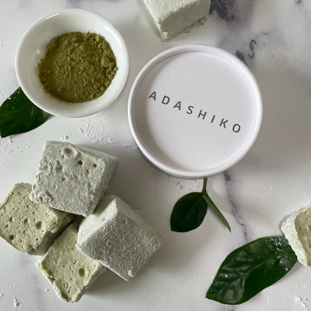 Collagen Matcha Marshmallows sitting next to a tub of Adashiko Pure Collagen Powder and a cup of Matcha Tea | Adashiko Collagen | 100% Natural Skincare