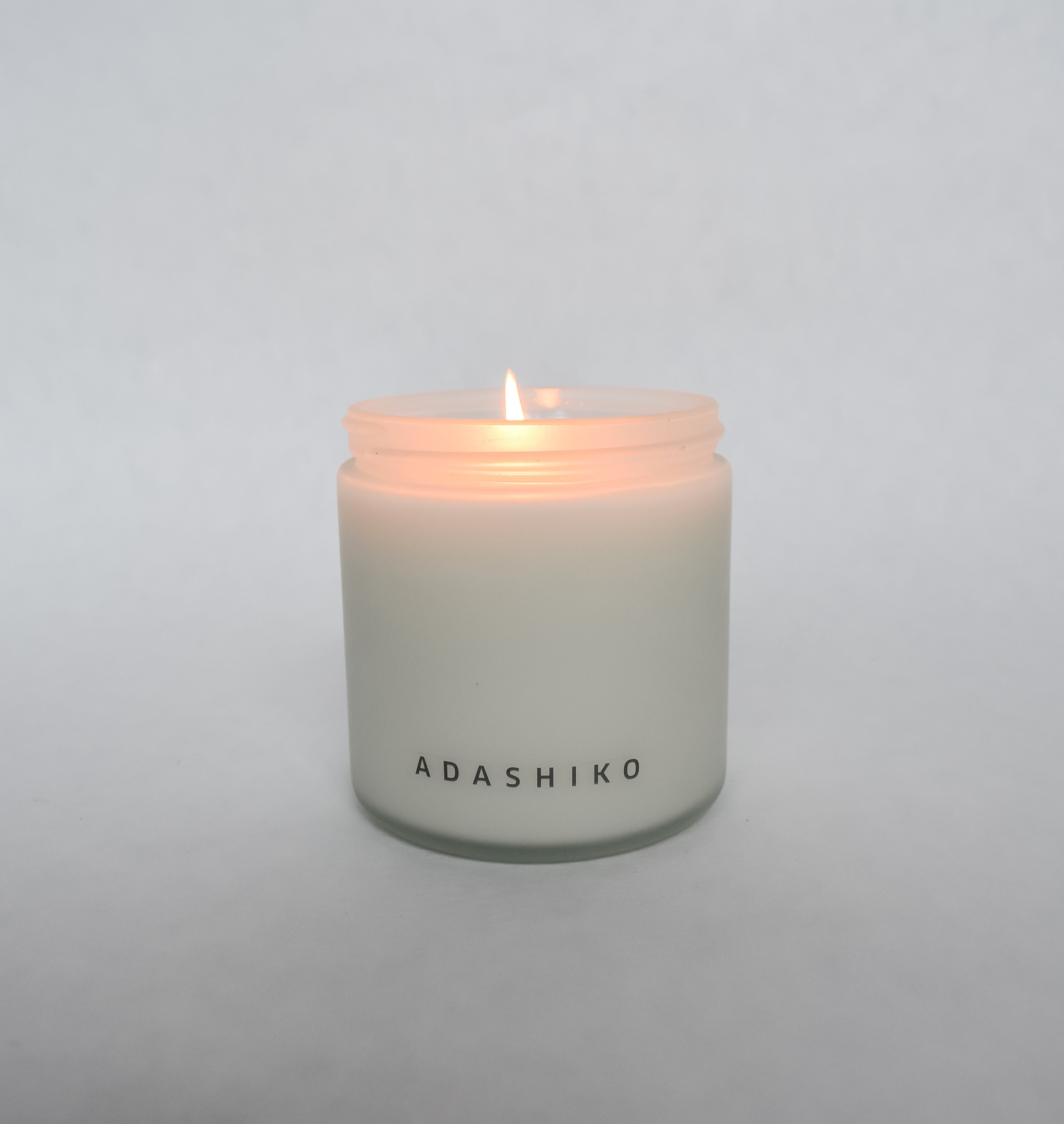 Woodlands Christmas Candle jar with lid off & lit | Adashiko Collagen | 100% Natural Skincare