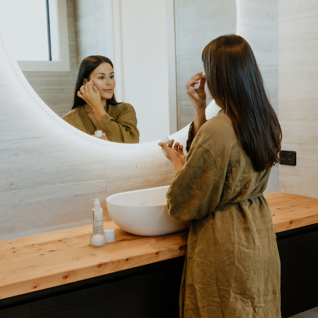 Model at her vanity mirror applying Collagen + Noni Gel moisturiser to her face | Adashiko Collagen | 100% Natural Skincare
