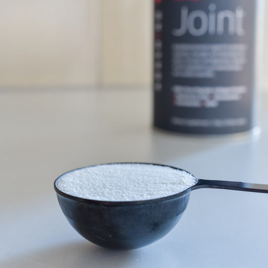 Scoop filled with Joint Collagen Powder next to a tub of powder | Adashiko Collagen | 100% Natural Skincare