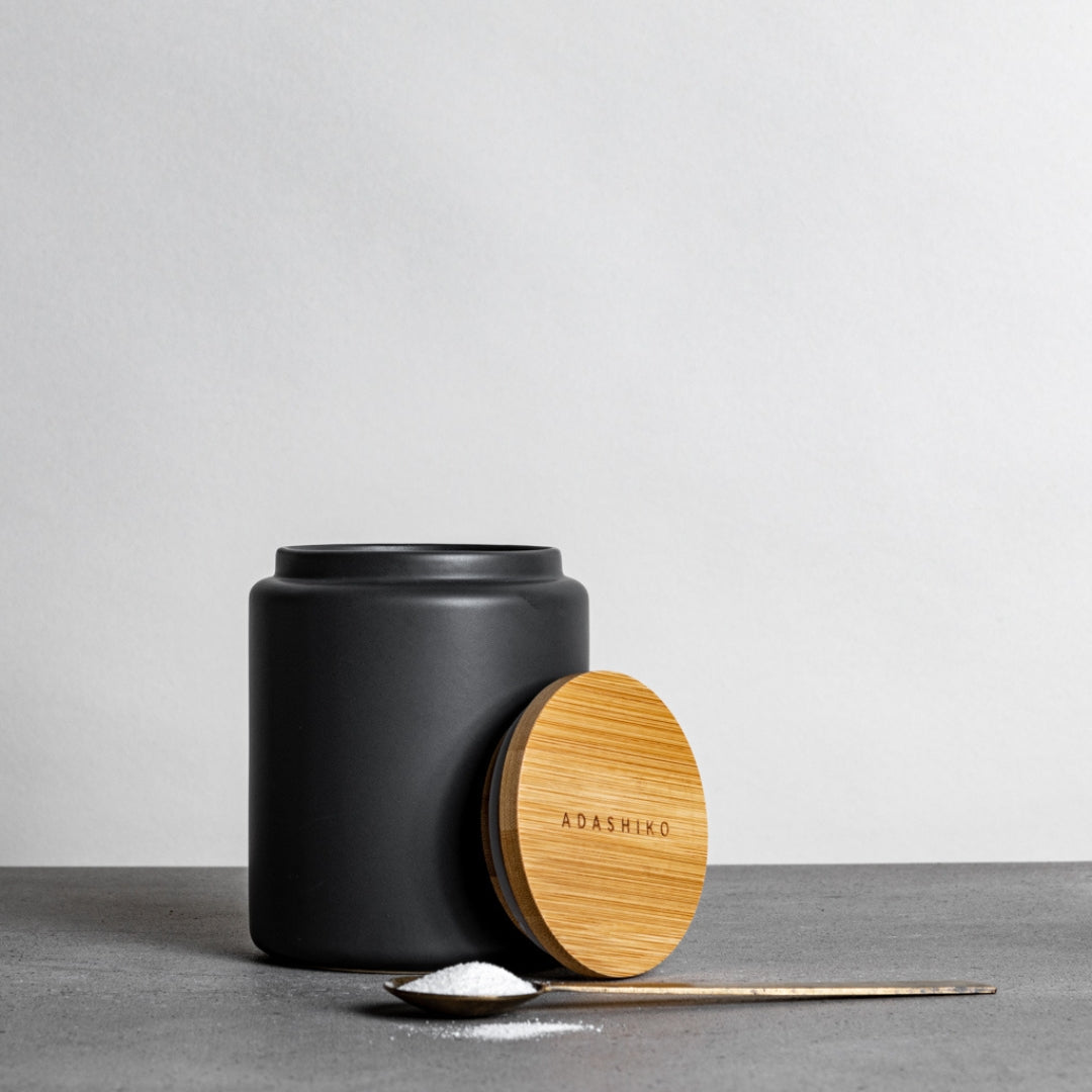 Reusable Ceramic Cannister sitting on benchtop lid off and spoon of collagen powder to the side | Adashiko Collagen | 100% Natural Skincare