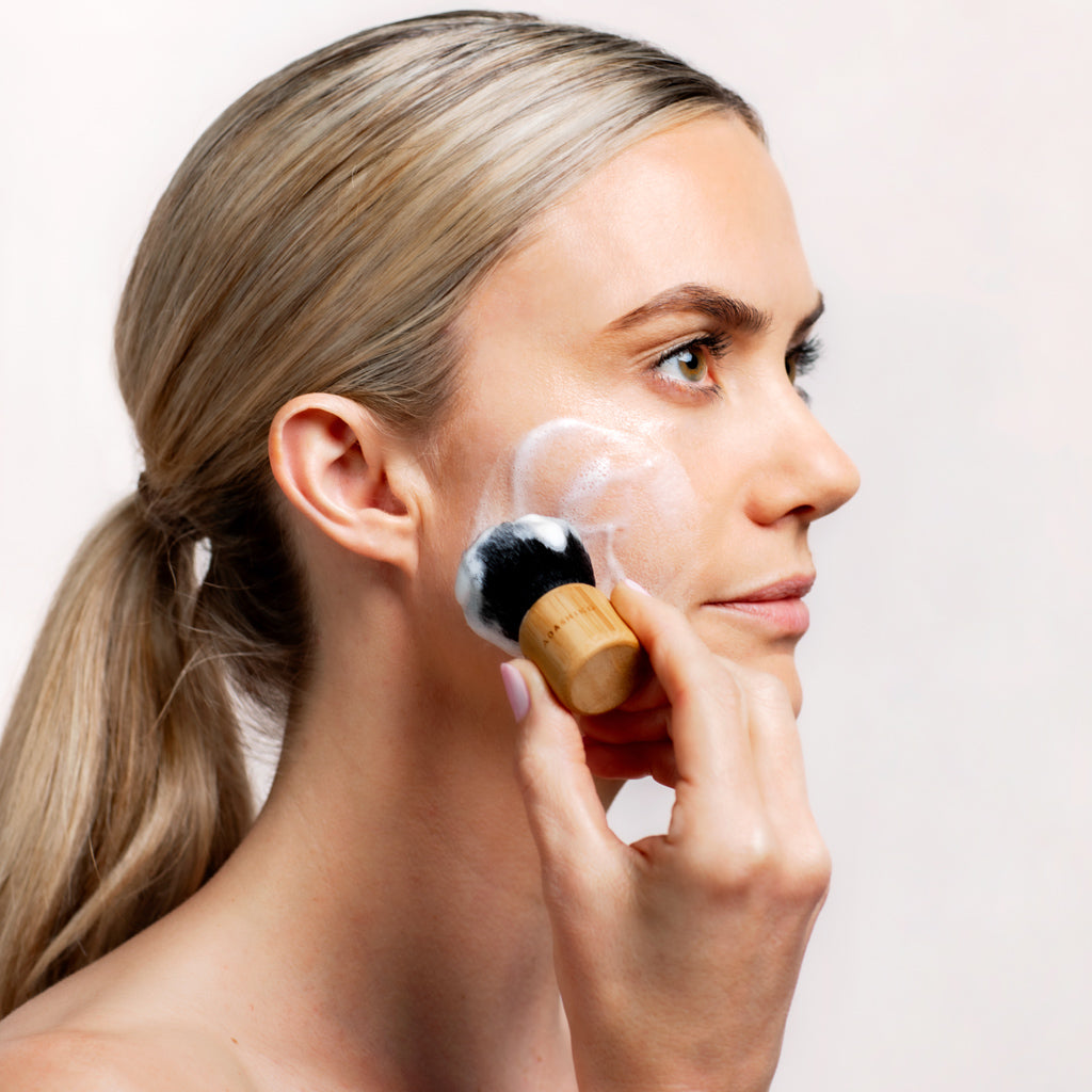 Model applying Collagen Cleanse to her face using a Kabuki Brush | Adashiko Collagen | 100% Natural Skincare