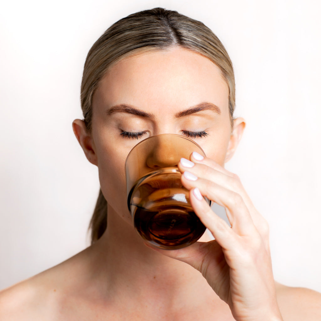 Model drinking a glass of water with Joint Collagen Powder dissolved | Adashiko Collagen 100% Natural Skincare