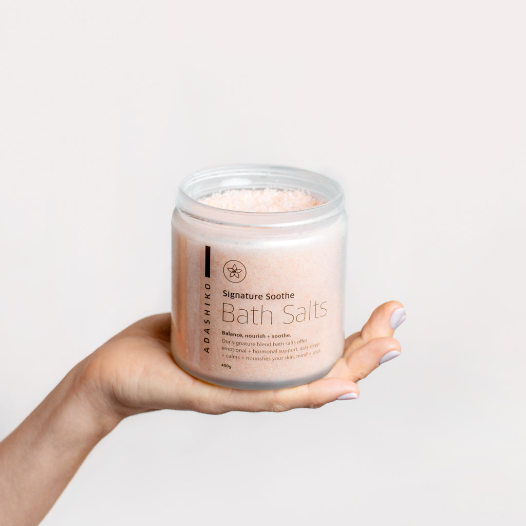 Open jar of Signature Soothe Bath Salts being held in a model's hand | Adashiko Collagen | 100% Natural Skincare
