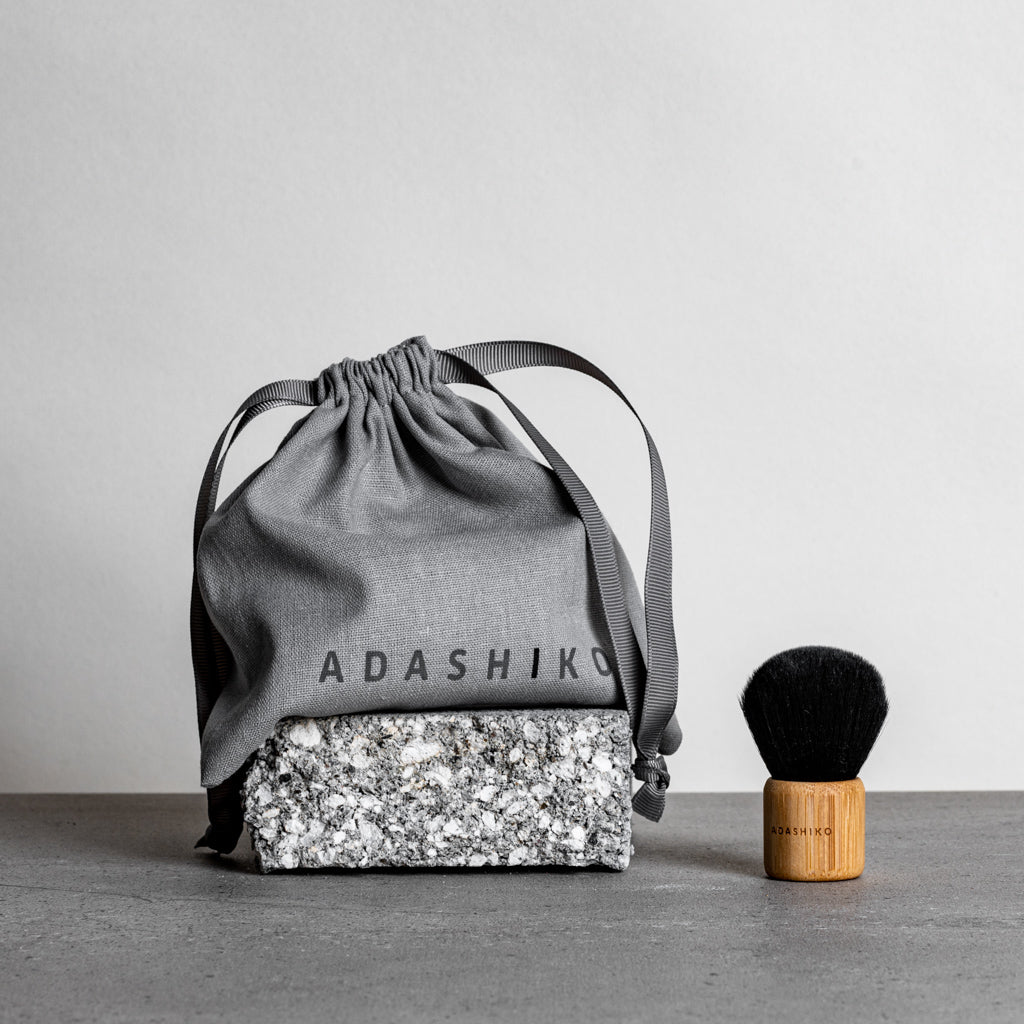 Kabuki Cleansing Brush next to Linen Travel Bag against a grey background | Adashiko Collagen | 100% Natural Skincare